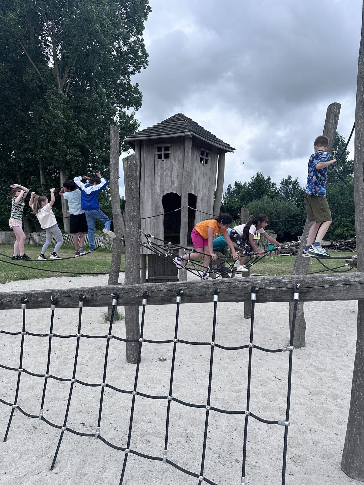 Children climbing on outdoor play equipment during the holiday programme