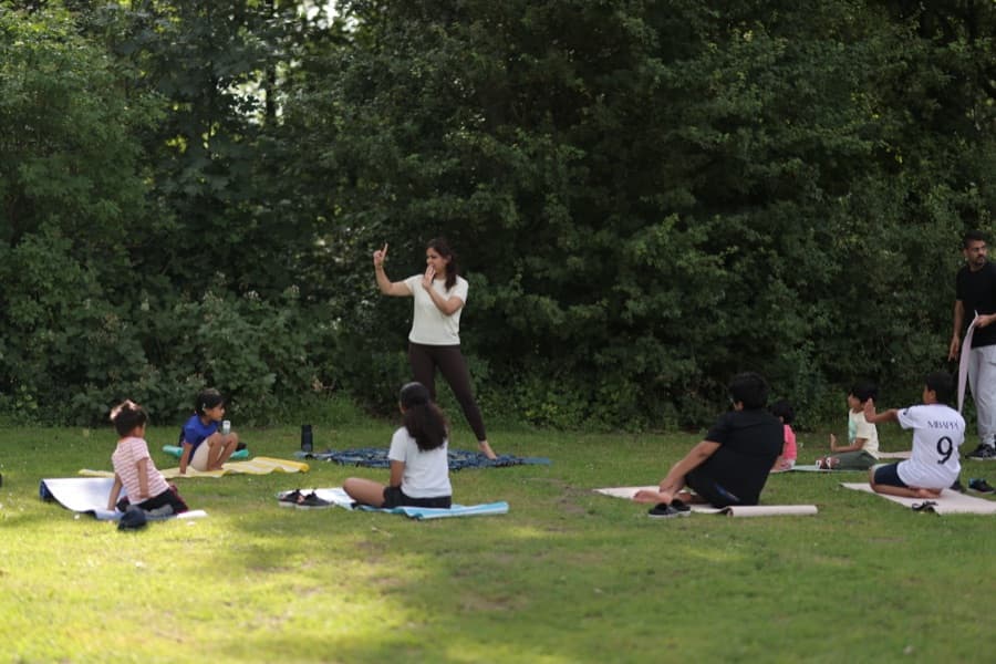 Gagan teaching a group of children outdoors on mats